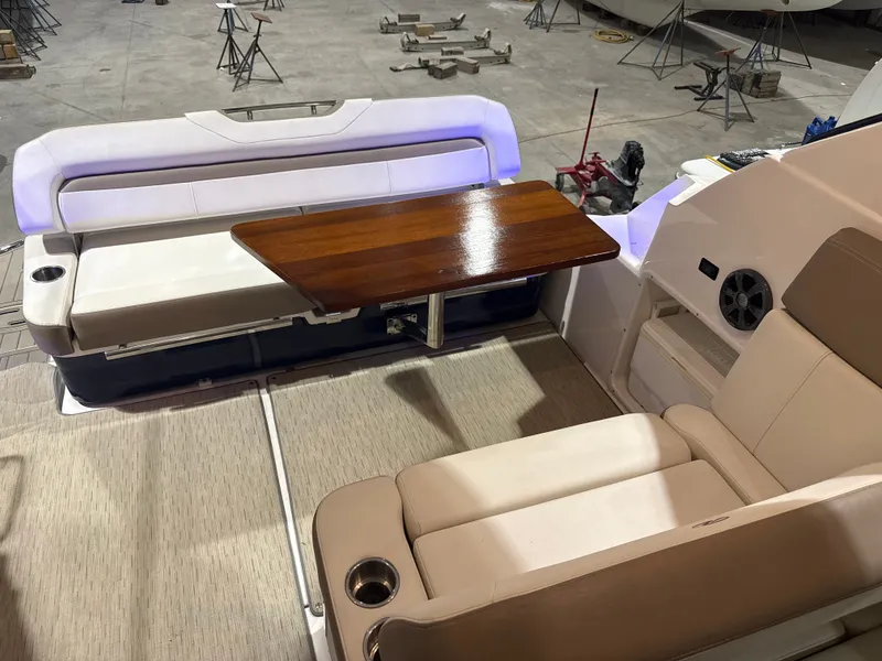 Slide: The Image of The image shows the interior of a 2018 Regal 35 Sport Coupe with beige seating and a wooden table. - 29