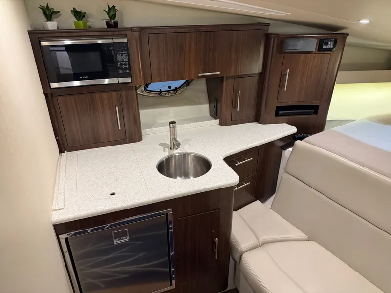 Slide: The Image of Interior of the 2018 Regal 35 Sport Coupe with modern kitchen, sink, and microwave. - 37