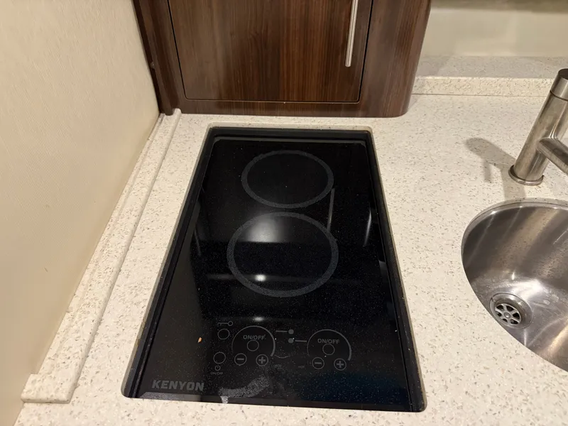 Slide: The Image of The 2018 Regal 35 Sport Coupe features a modern cooktop and sink in its galley. - 44
