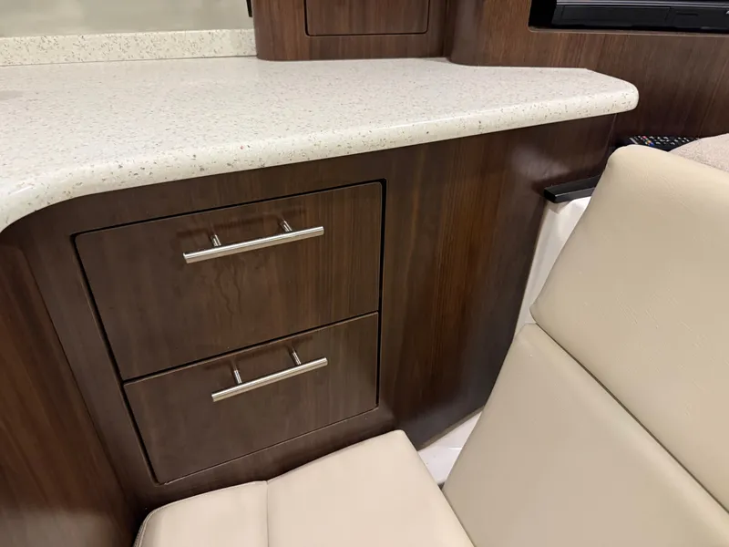 Slide: The Image of Interior of a 2018 Regal 35 Sport Coupe with wooden cabinets and a beige upholstered chair. - 43