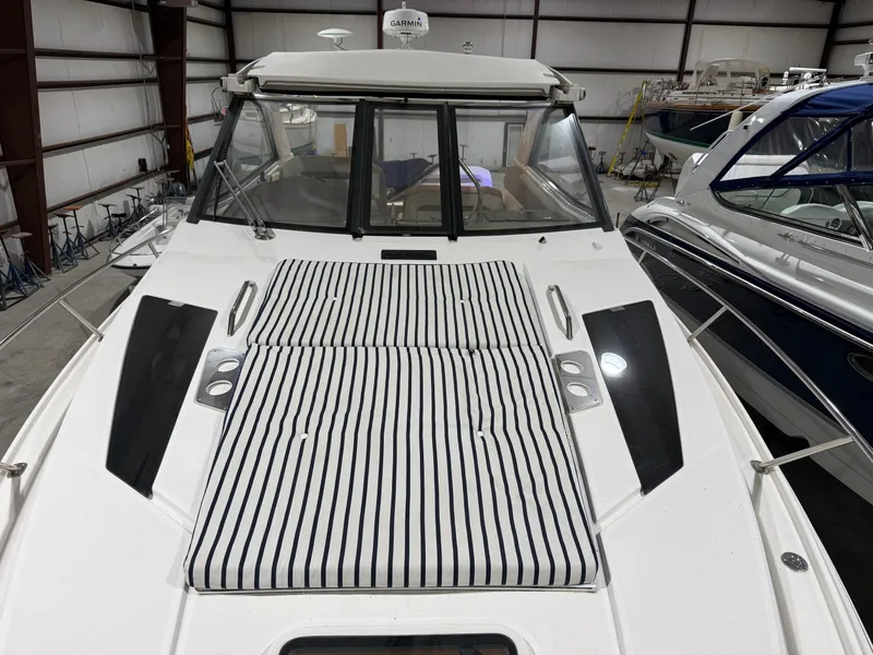 Slide: The Image of A 2018 Regal 35 Sport Coupe with striped cushions on the foredeck, stored in a warehouse. - 7