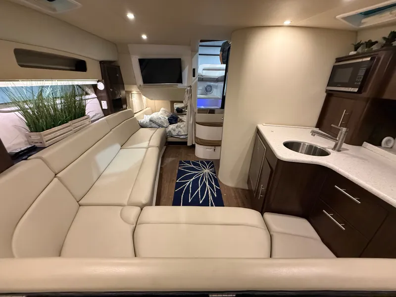 Slide: The Image of Interior of a 2018 Regal 35 Sport Coupe with beige sofa, kitchenette, and bed. - 3