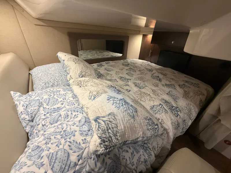 Slide: The Image of The cabin of the 2018 Regal 35 Sport Coupe features a cozy bed with patterned bedding. - 40
