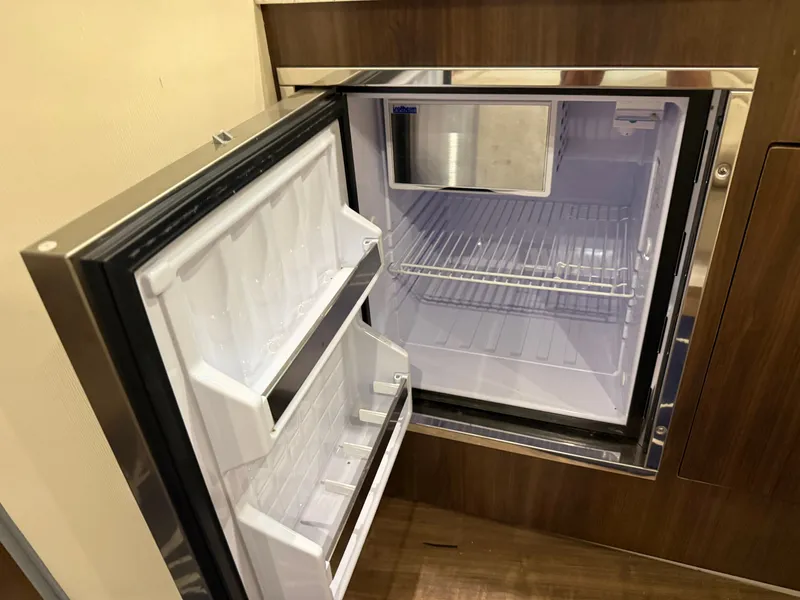 Slide: The Image of An open refrigerator in a 2018 Regal 35 Sport Coupe. It features a freezer compartment at the top. - 42