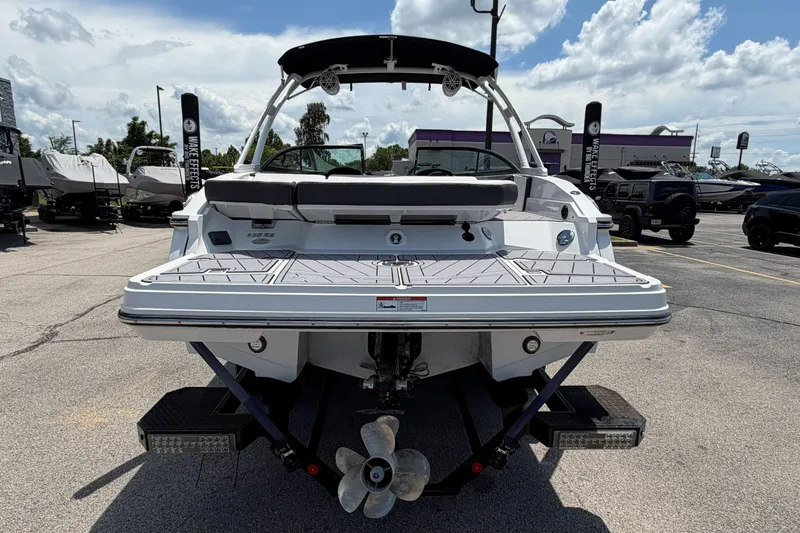 Slide: The Image of 2023 Monterey 238SS Super Sport boat, rear view, in a parking lot under a cloudy sky. - 3