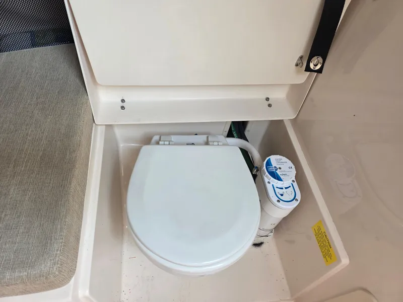 Slide: The Image of The image shows a toilet in a boat, surrounded by beige surfaces. - 18