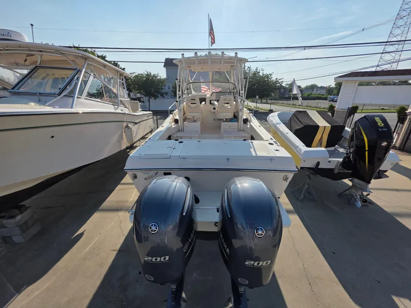 Slide: The Image of A 2022 Grady-White Gulfstream 232 boat with twin outboard engines, parked on a concrete lot. - 6