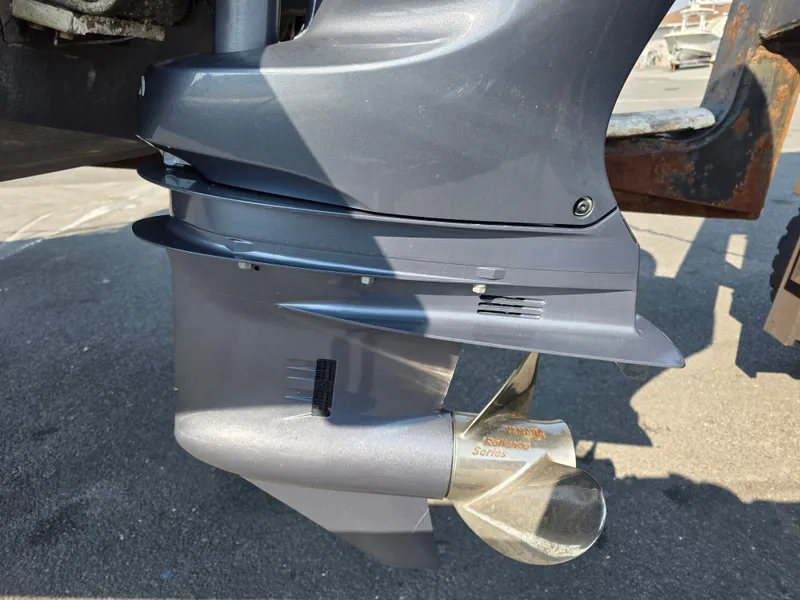 Slide: The Image of Close-up of an outboard motor with a shiny propeller blade, mounted on a boat. - 25