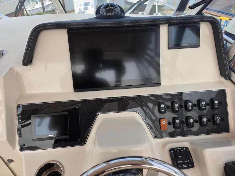 Slide: The Image of The image shows the dashboard of a Grady-White Gulfstream 232 boat with multiple screens and switches. - 9