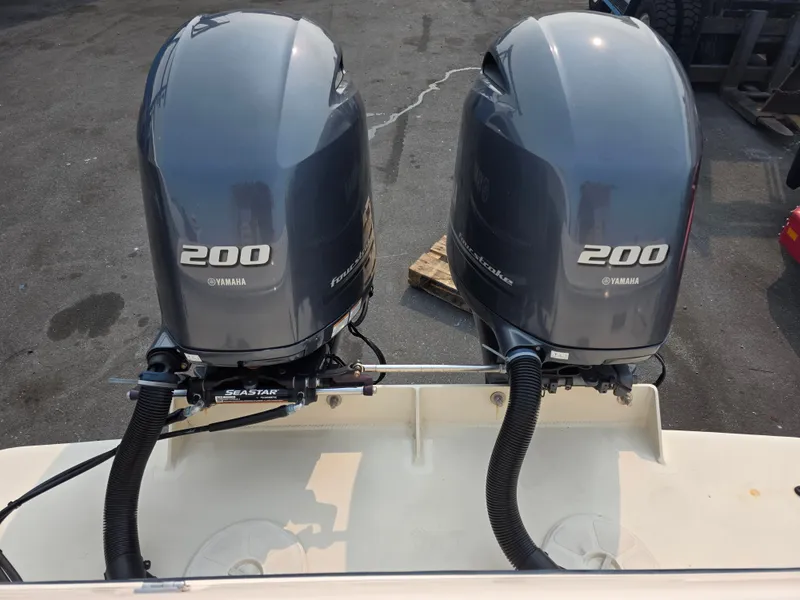 Slide: The Image of Two Yamaha 200 outboard engines are mounted on the stern of a boat. They are dark gray and shiny. - 6