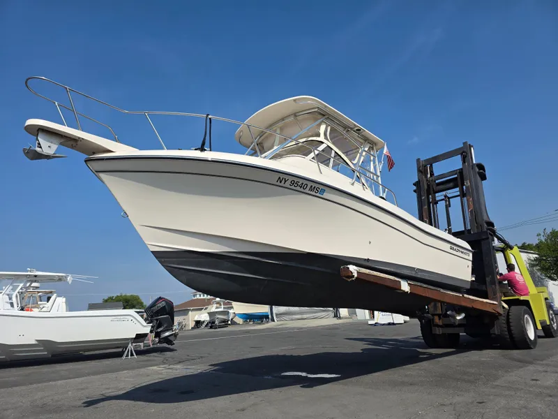 Slide: The Image of A 2022 Grady-White Gulfstream 232 boat being lifted by a forklift. - 3