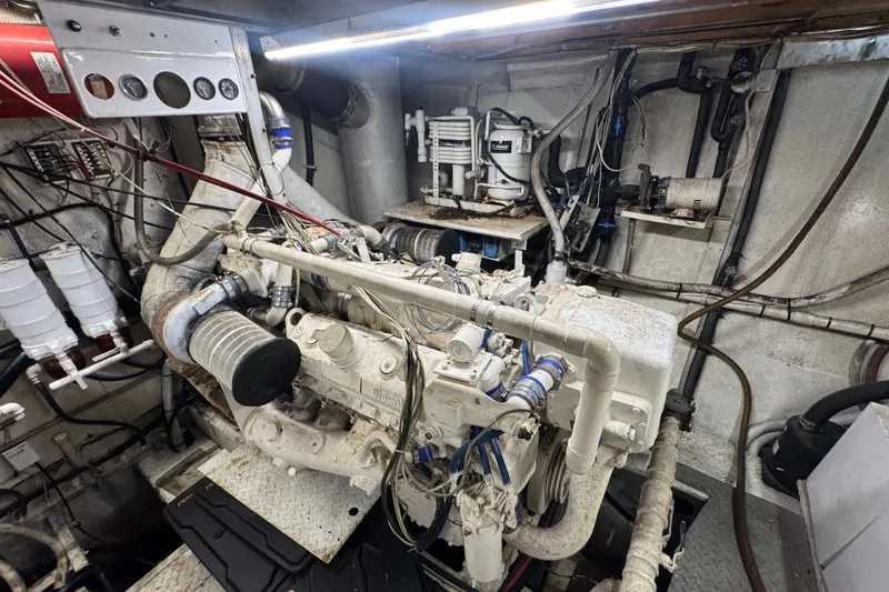 Slide: The Image of Engine room of a 1981 Broward 72 Motor Yacht, showcasing mechanical components and piping. - 27