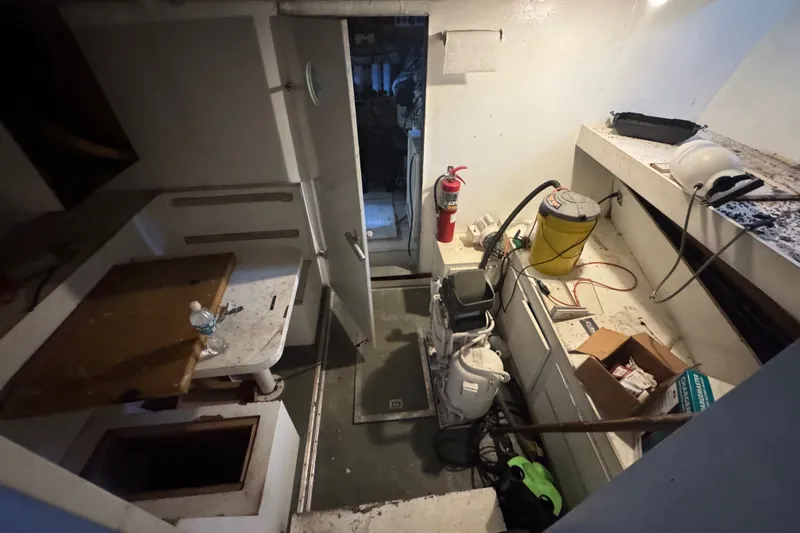 Slide: The Image of Interior of 1981 Broward 72 Motor Yacht showing maintenance area with tools and equipment. - 25