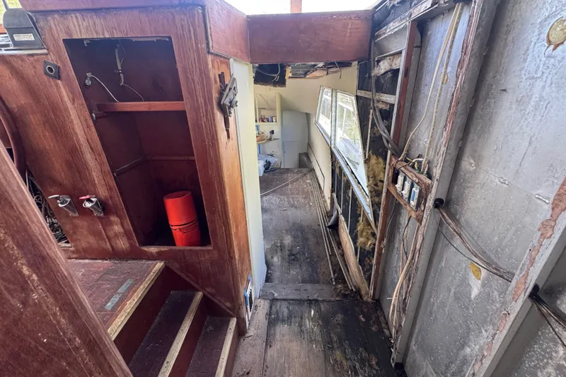 Slide: The Image of Interior of a 1981 Broward 72 Motor Yacht showing wooden cabinetry and exposed wiring. - 17