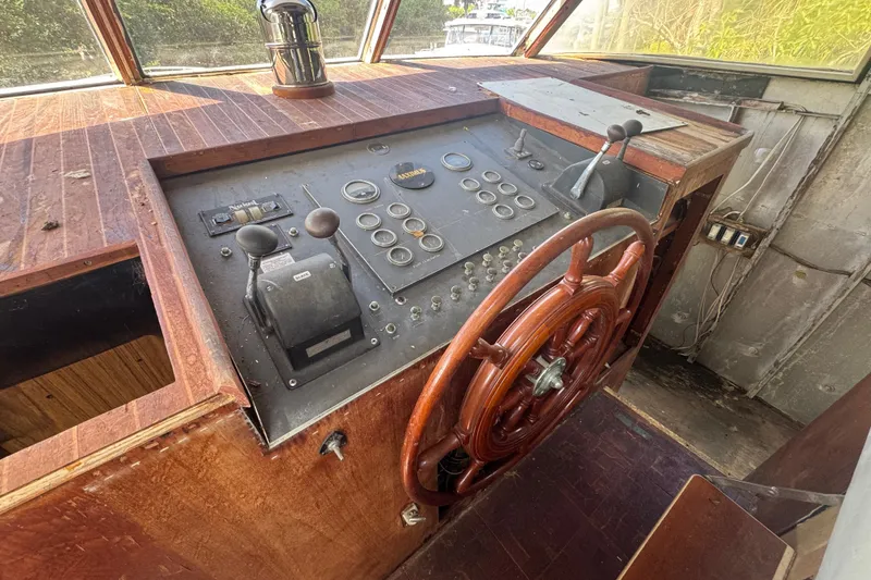 Slide: The Image of 1981 Broward 72 Motor Yacht helm with wooden wheel and vintage controls. - 11