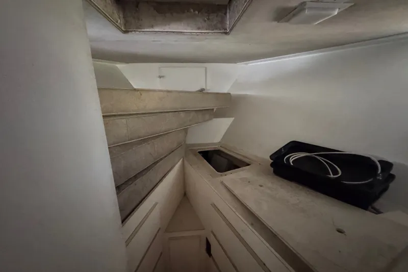 Slide: The Image of Interior of 1981 Broward 72 Motor Yacht showing storage area with shelves and a black container. - 23