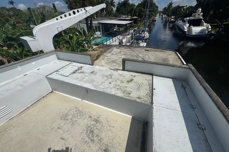 Slide: The Image of 1981 Broward 72 Motor Yacht deck overlooking a serene canal with lush greenery. - 16