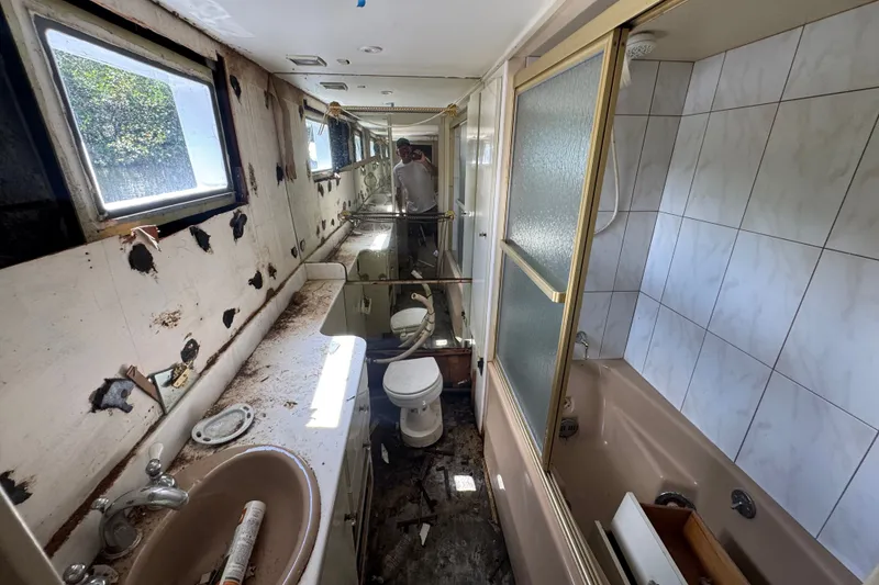 Slide: The Image of Interior of a 1981 Broward 72 Motor Yacht bathroom, showing wear and damage. - 35