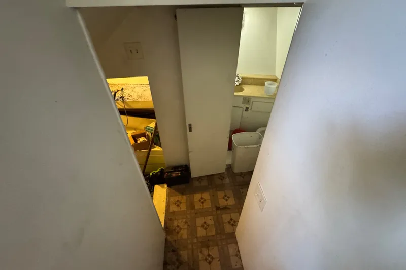 Slide: The Image of Interior view of 1981 Broward 72 Motor Yacht showing a narrow passageway and utility area. - 21