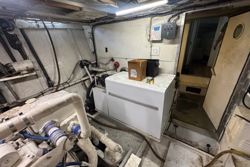 Slide: The Image of Engine room of a 1981 Broward 72 Motor Yacht, featuring machinery and storage. - 30