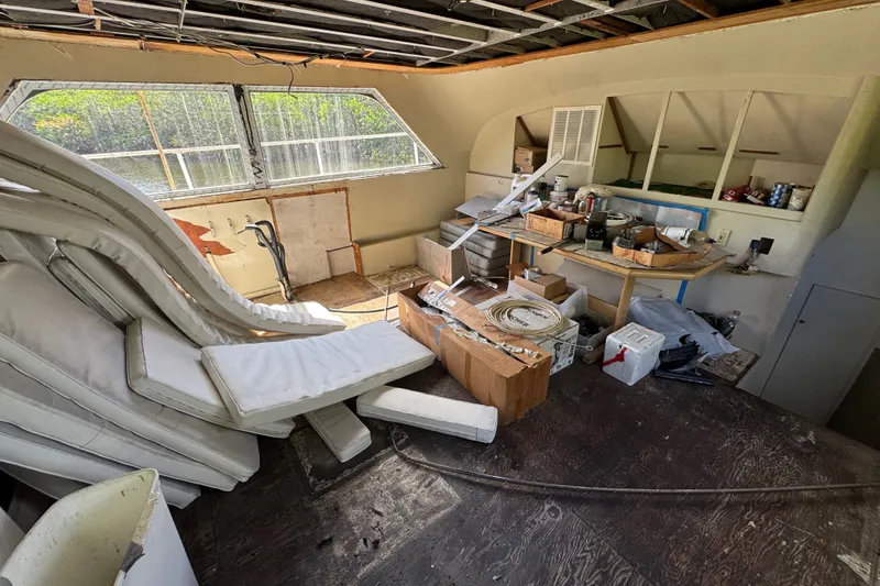 Slide: The Image of Interior of a 1981 Broward 72 Motor Yacht under renovation, with scattered cushions and tools. - 18