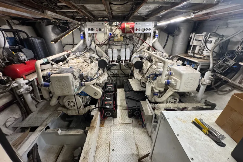 Slide: The Image of Engine room of a 1981 Broward 72 Motor Yacht with dual engines and mechanical equipment. - 26
