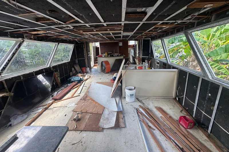 Slide: The Image of Interior of a 1981 Broward 72 Motor Yacht under renovation, showing stripped walls and scattered materials. - 8