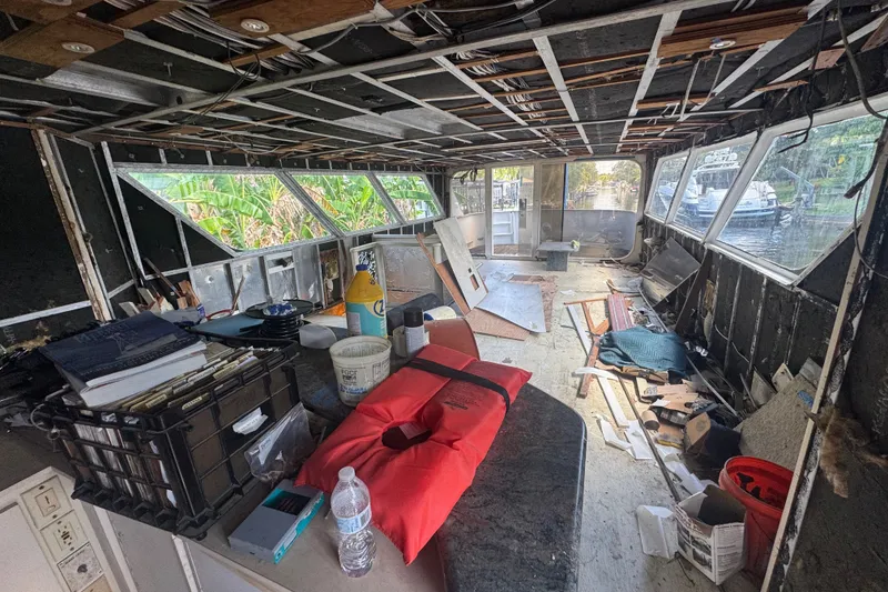 Slide: The Image of Interior of a 1981 Broward 72 Motor Yacht under renovation, showing clutter and exposed framework. - 9