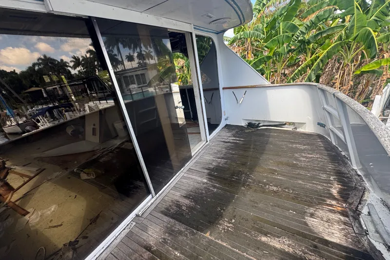 Slide: The Image of 1981 Broward 72 Motor Yacht deck with glass doors and tropical surroundings. - 7