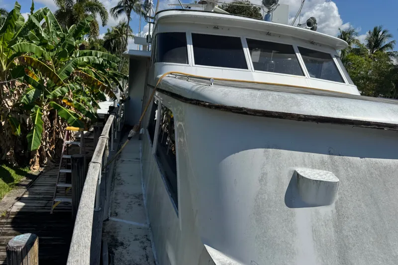 Slide: The Image of 1981 Broward 72 Motor Yacht docked near tropical foliage under a clear sky. - 3