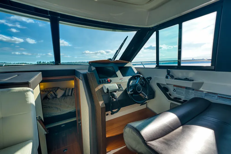 Slide: The Image of 2017 Tiara Yachts C39 Coupe interior with helm, seating, and cabin view. - 16