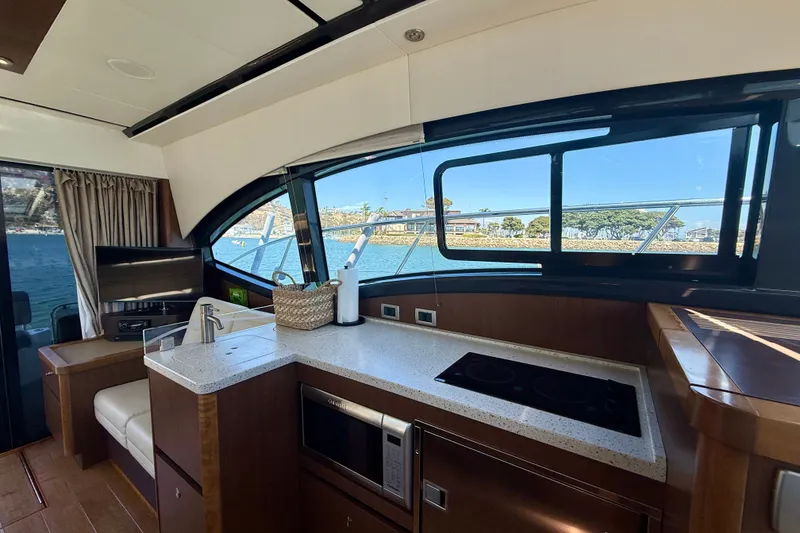 Slide: The Image of Interior of 2016 Sea Ray Sundancer 400 yacht with modern kitchen and scenic window view. - 20