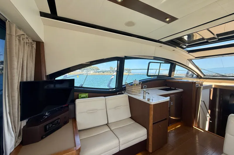 Slide: The Image of Interior of 2016 Sea Ray Sundancer 400 yacht with modern seating and kitchenette. - 12