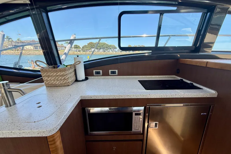 Slide: The Image of Interior view of 2016 Sea Ray Sundancer 400 yacht kitchen with modern appliances. - 19