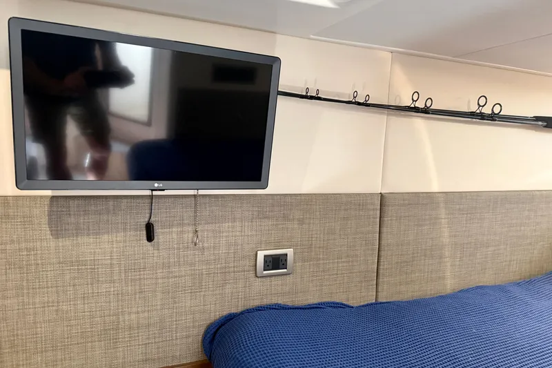 Slide: The Image of Interior of 2016 Sea Ray Sundancer 400 with wall-mounted TV and fishing rod holder. - 47