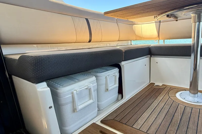 Slide: The Image of 2016 Sea Ray Sundancer 400 interior with cushioned seating and storage coolers. - 50