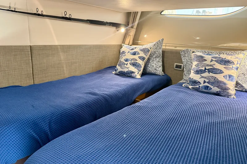 Slide: The Image of Interior of 2016 Sea Ray Sundancer 400 with twin beds and nautical-themed pillows. - 46