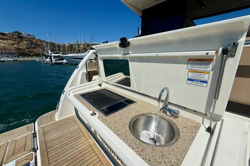 Slide: The Image of Outdoor kitchenette on 2016 Sea Ray Sundancer 400 yacht with sink and grill, docked at marina. - 52