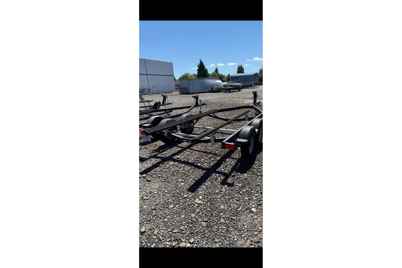Slide: The Image of Trailer for 2021 Bayliner VR6 Bowrider I/O on gravel lot under clear sky. - 22