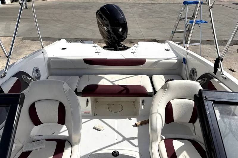 Slide: The Image of 2019 Tahoe 550 TS boat interior with white and maroon seating, Mercury engine visible. - 16