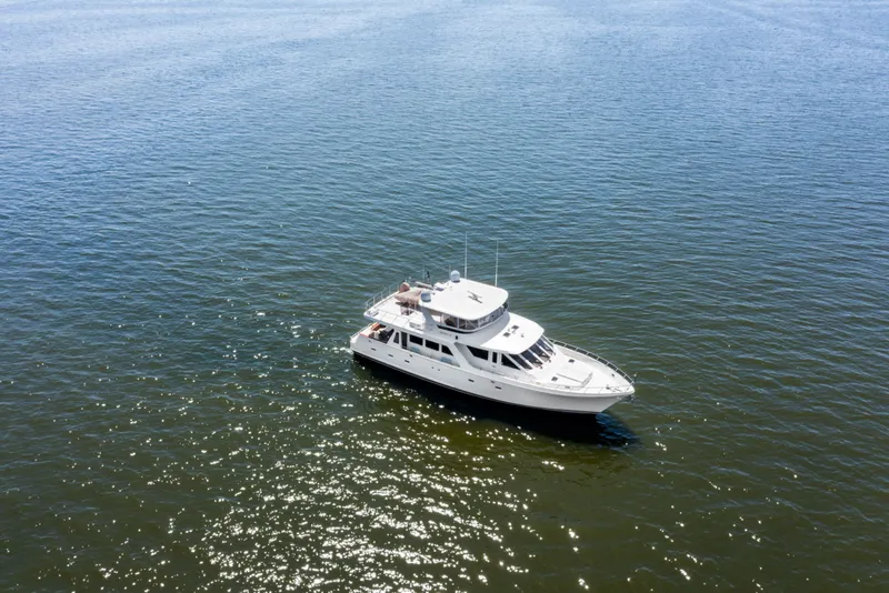 Slide: The Image of 2005 Offshore Yachts 66 Pilot House cruising on open water under clear skies. - 58