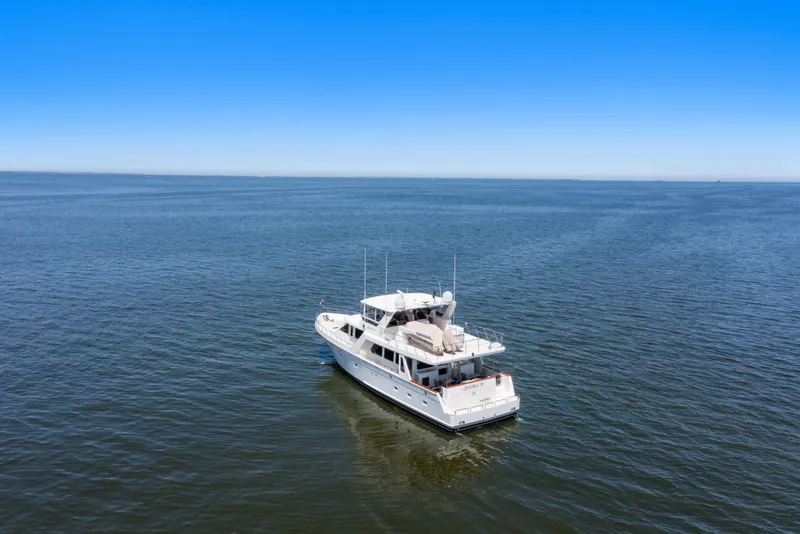 Slide: The Image of 2005 Offshore Yachts 66 Pilot House cruising on open water under clear blue sky. - 62