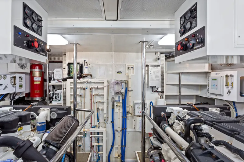 Slide: The Image of Engine room of 2005 Offshore Yachts 66 Pilot House, featuring dual engines and control panels. - 49