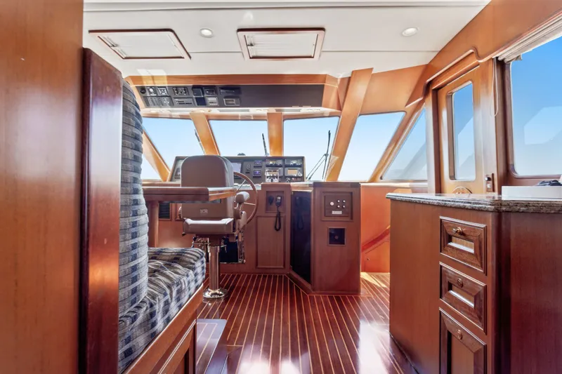 Slide: The Image of Luxurious 2005 Offshore Yachts 66 Pilot House interior with polished wood and modern navigation controls. - 14