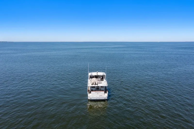 Slide: The Image of 2005 Offshore Yachts 66 Pilot House on open sea under clear blue sky. - 61