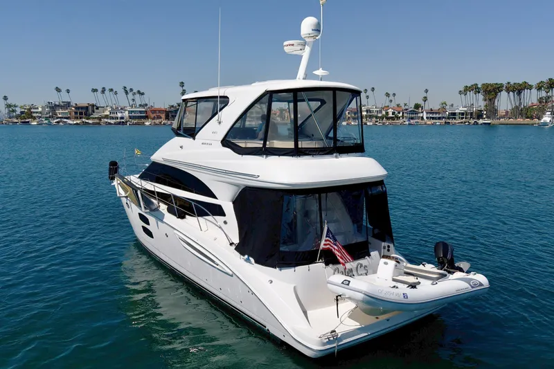Slide: The Image of A white 2014 Meridian 441 Sedan yacht on calm water, with a flag at the stern. - 1