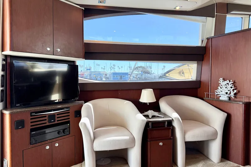 Slide: The Image of The interior of a 2014 Meridian 441 Sedan features two white chairs, a TV, and a window overlooking the harbor. - 14