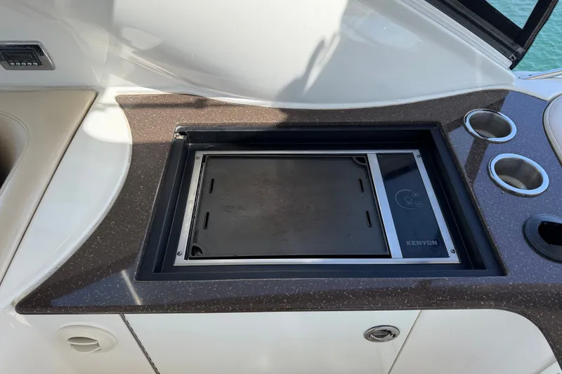Slide: The Image of A built-in grill on a boat with a dark countertop and cup holders. - 41