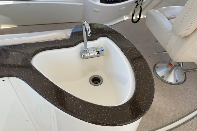 Slide: The Image of A sleek sink with a modern faucet on a boat, surrounded by beige carpeting. - 43