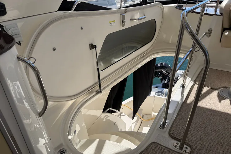 Slide: The Image of The staircase on the Meridian 441 Sedan leads down from the flybridge, featuring stainless steel railings. - 38